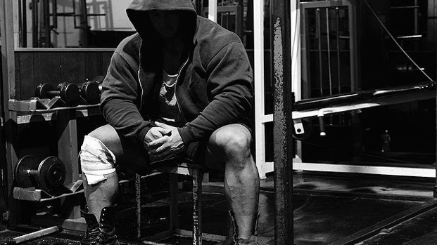 Hooded strength athlete seated in a gym for the Boring But Big 5/3/1 program