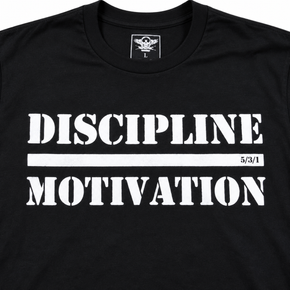 Close-up of the white Discipline Over Motivation print on a black shirt.
