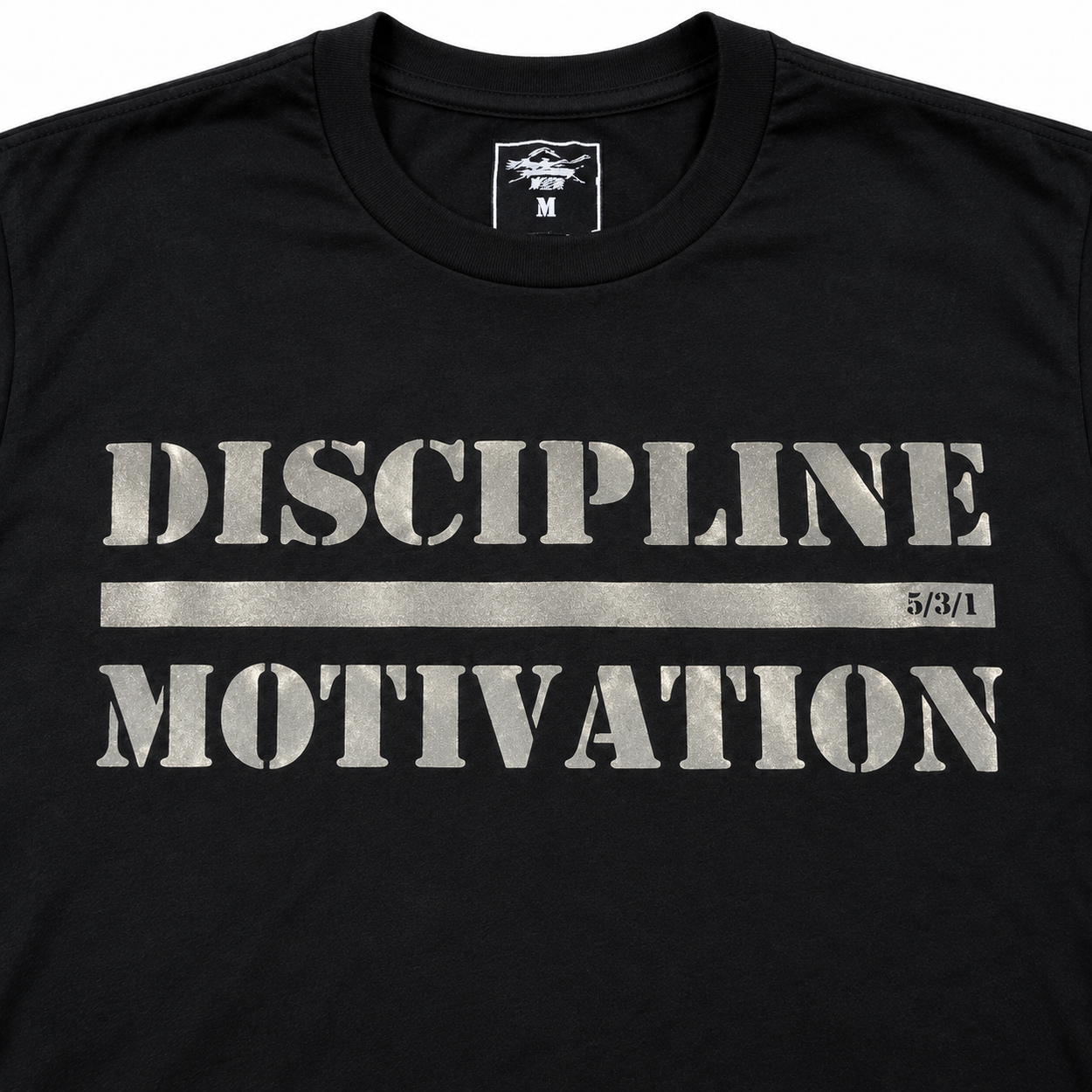 Close-up of the Discipline Over Motivation design reflecting silver on a black shirt